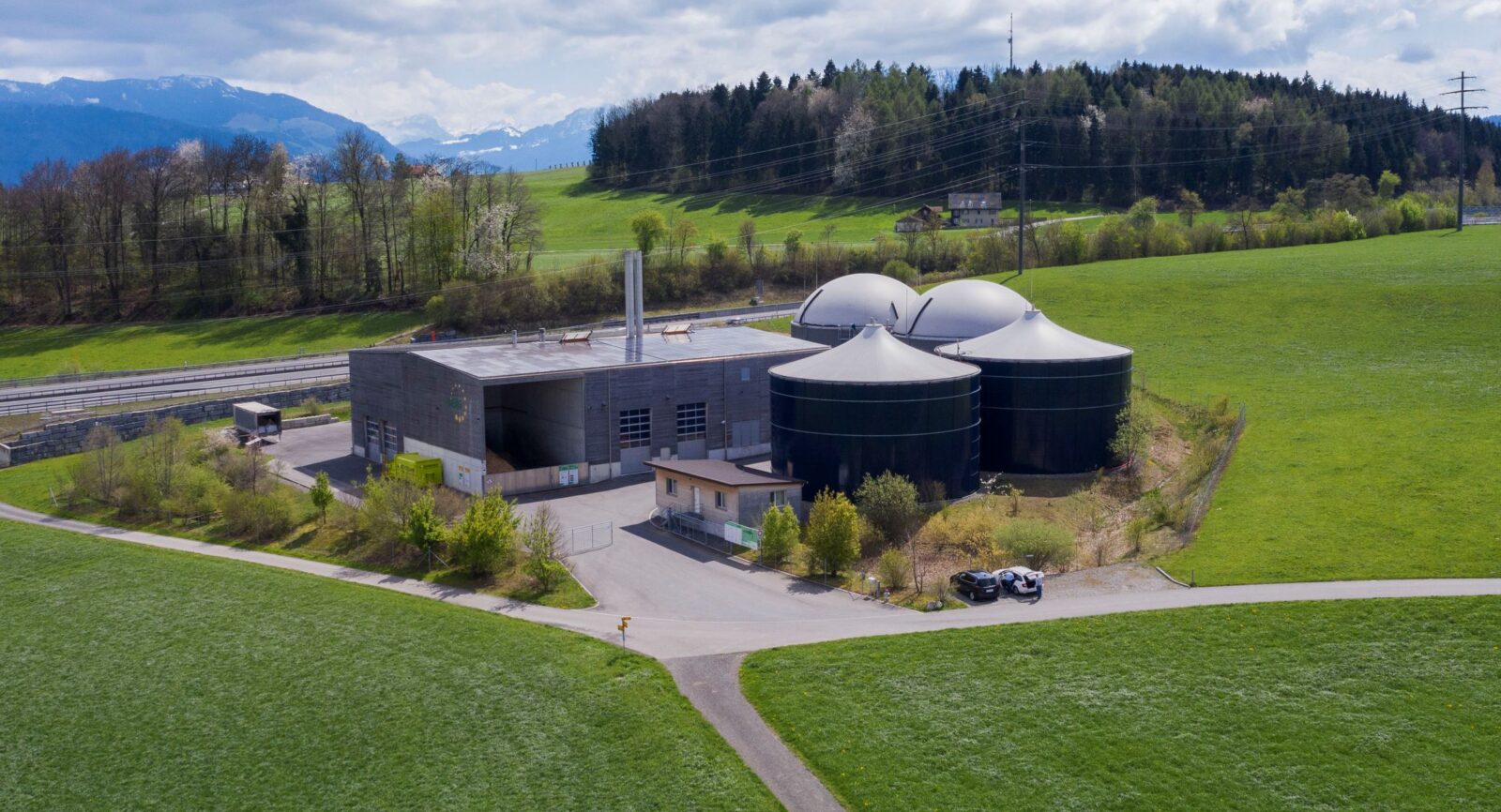 Flugaufnahme auf die Biomasse-Heizkraftwerk mit Werkgebäude (li.), 2 Fermenter mit Gashauben (re. i. Hintergr.), 2 Güllenlager (re. i. Vordergrund) 