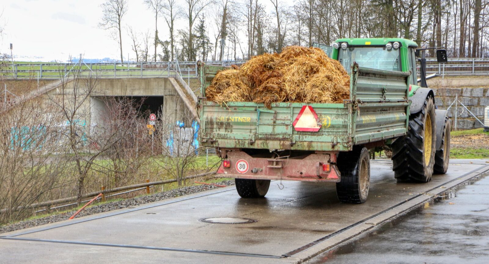 Trockenes Gärsubstrat wird nach wie vor mit landwirtschaftlichen Nutzfahrzeugen angeliefert.